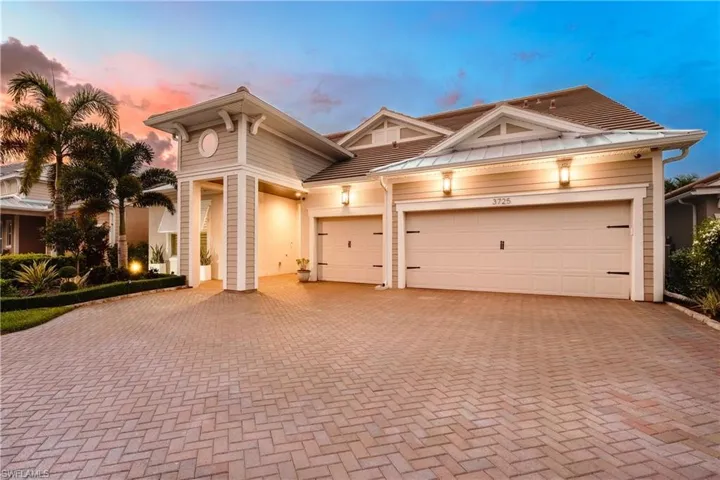 View of front of home with decorative driveway and a garage