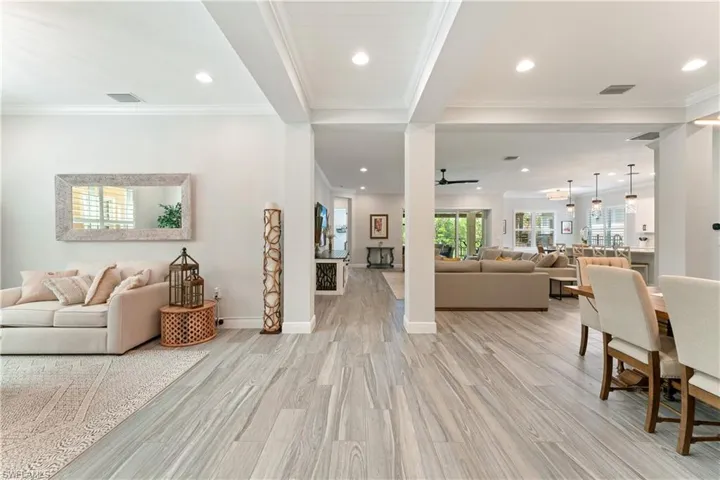 Living area featuring light wood finished floors, ornamental molding, ceiling fan, and recessed lighting
