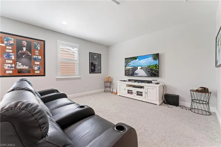 Living area with light carpet and baseboards