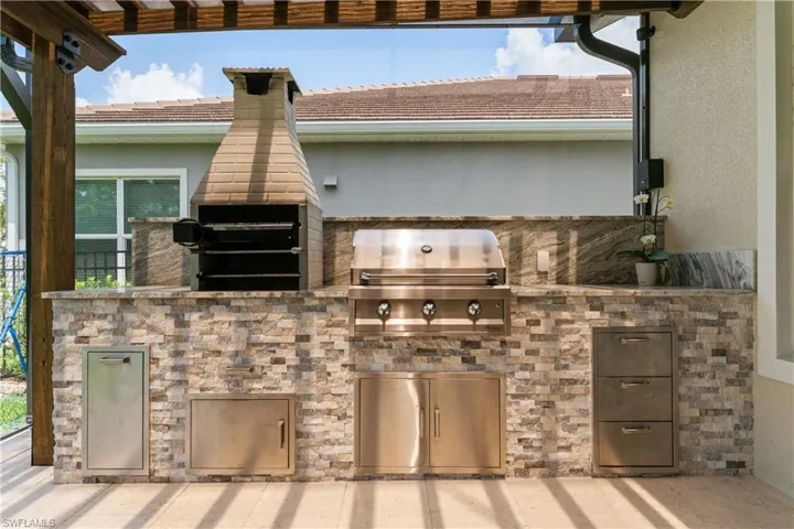 View of patio with a pergola and area for grilling