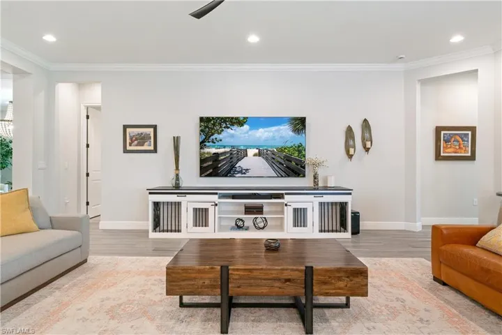Living area featuring recessed lighting, ornamental molding, and light wood-style floors