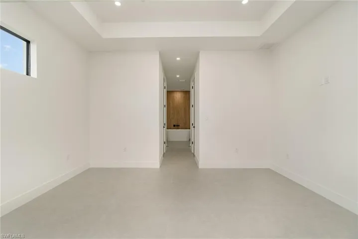 Empty room featuring a tray ceiling and light tile patterned floors