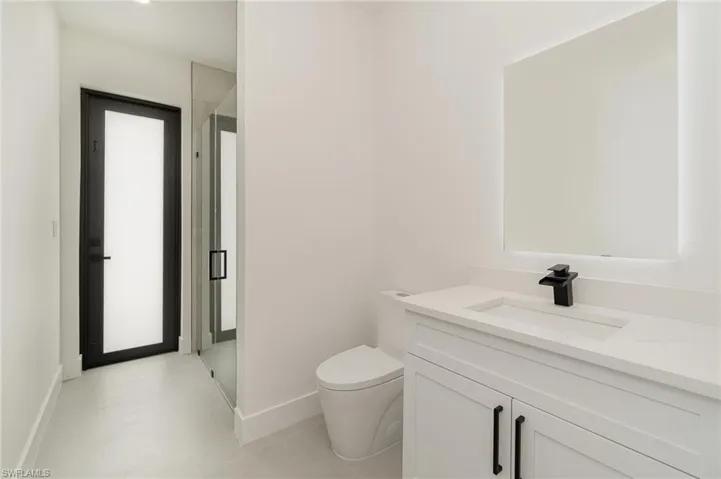 Bathroom with vanity, an enclosed shower, and toilet
