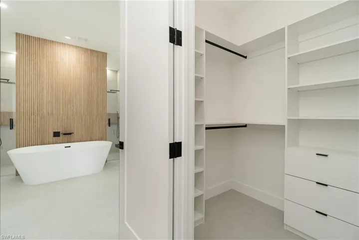 Walk in closet with light tile patterned floors