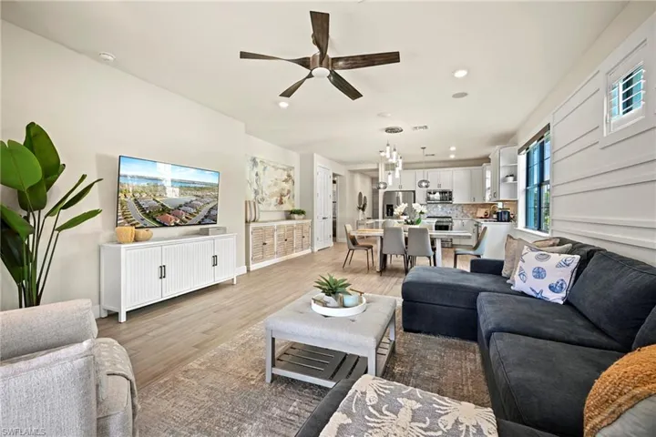 Living area with a ceiling fan, light wood-style floors, and recessed lighting