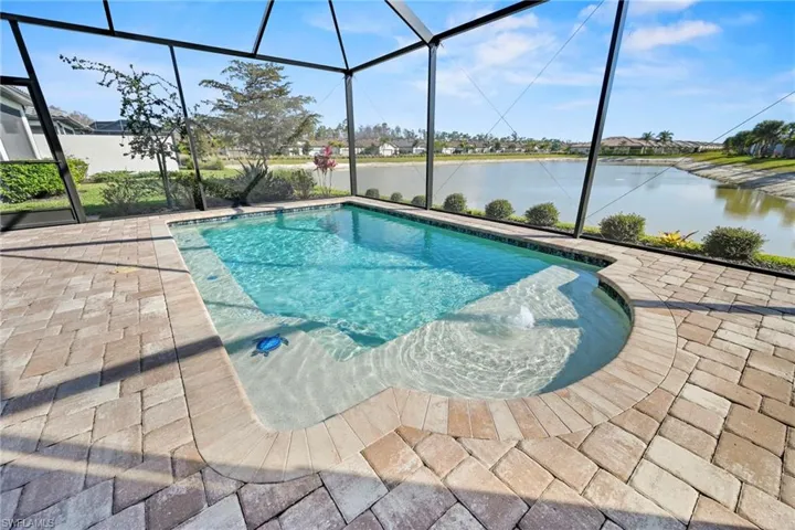 Outdoor pool with a sunroom, a lanai, a water view, a patio, and a residential view
