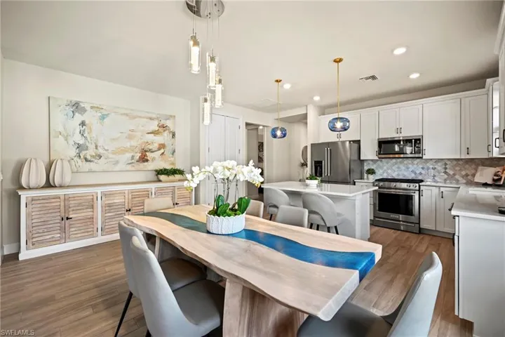 Dining area with light wood-type flooring and recessed lighting