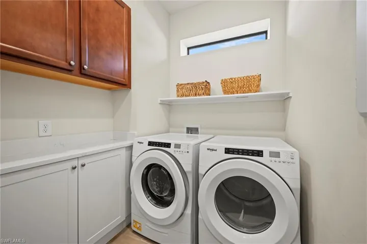 Laundry area featuring cabinet space and washing machine and clothes dryer