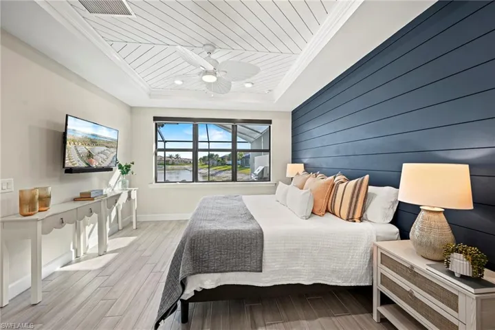 Bedroom with wooden walls, wood tiled floors, an accent wall, wood ceiling, and ceiling fan