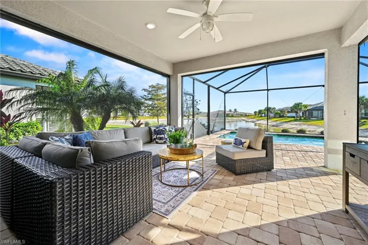 Sunroom with an outdoor living space, a patio, a ceiling fan, and a residential view