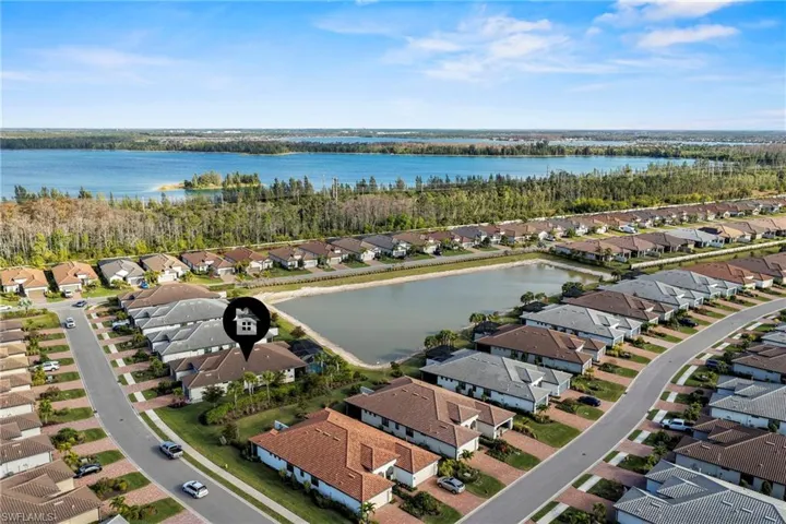 Aerial view of property and surrounding area with a large body of water and nearby suburban area