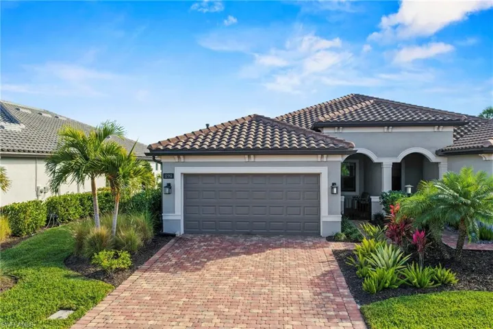 Mediterranean / spanish home with stucco siding, decorative driveway, a garage, and a tile roof