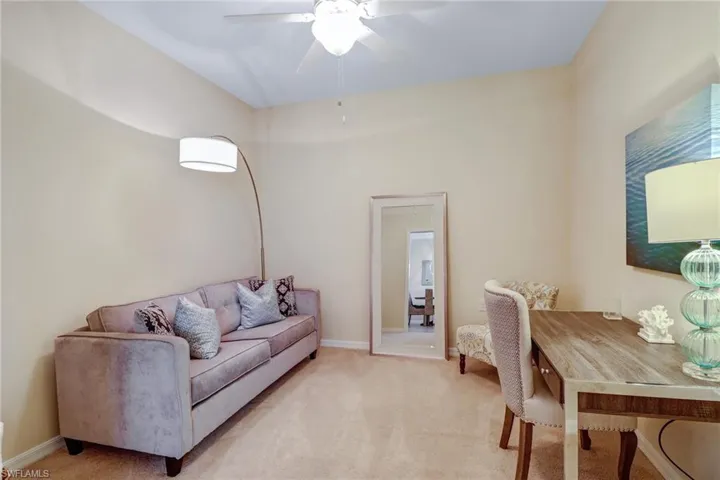Living area with light carpet and ceiling fan