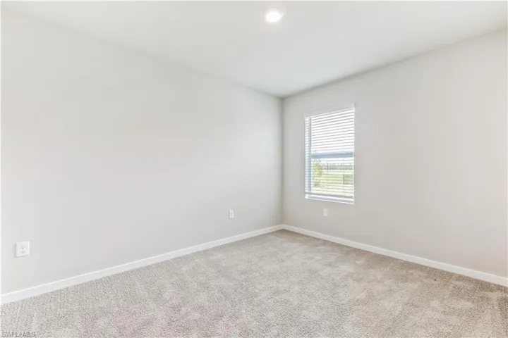 Spare room with baseboards and carpet