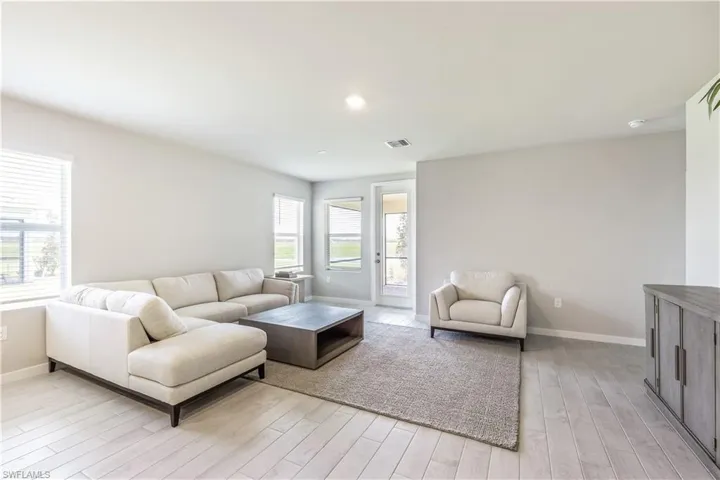 Living room with light wood-style floors and recessed lighting