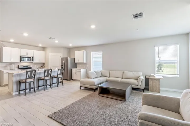 Living area with light wood-style flooring and recessed lighting