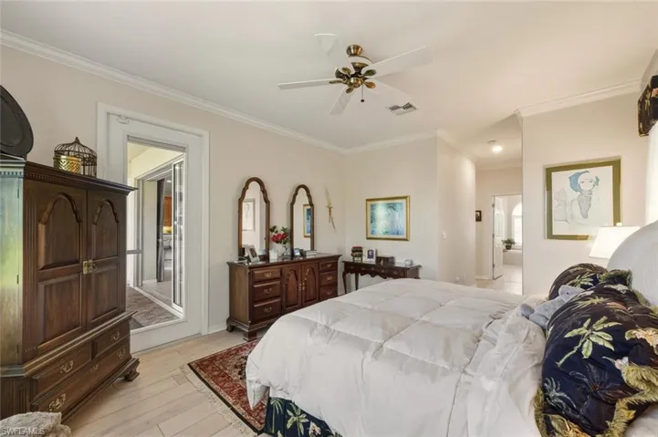 Bedroom with ornamental molding, light wood-style flooring, and ceiling fan
