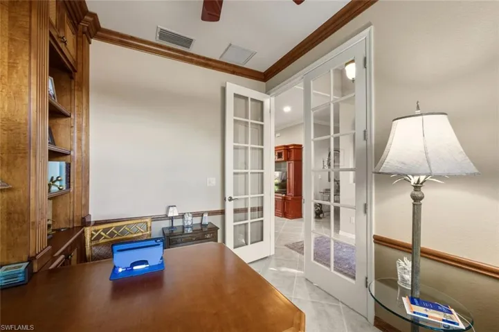 Unfurnished office featuring crown molding, french doors, ceiling fan, and light tile patterned flooring