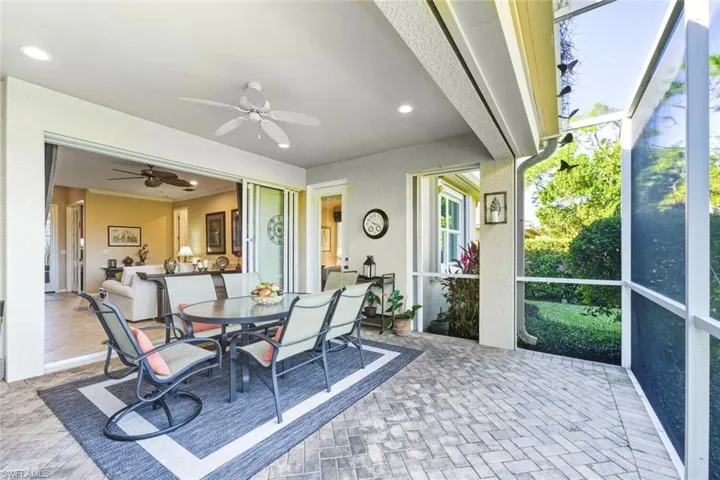 Sunroom with outdoor dining area and ceiling fan