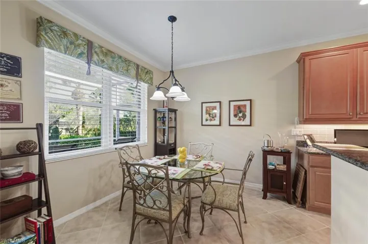 Dining space with crown molding and light tile patterned flooring