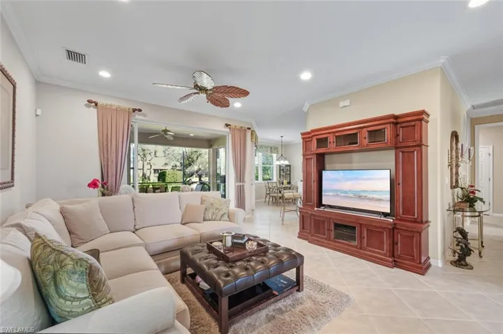 Living area featuring ornamental molding, light tile patterned floors, a ceiling fan, and recessed lighting