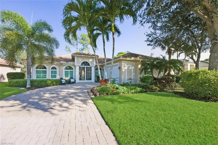Mediterranean / spanish-style house with stucco siding, decorative driveway, a front lawn, a tiled roof, and french doors