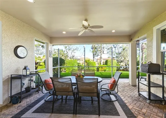 Sunroom / solarium with a textured wall, brick floors, and recessed lighting