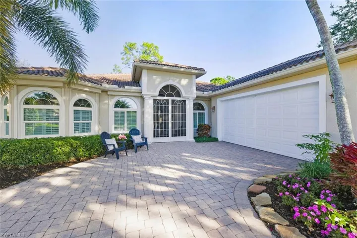 View of patio with decorative driveway and a garage