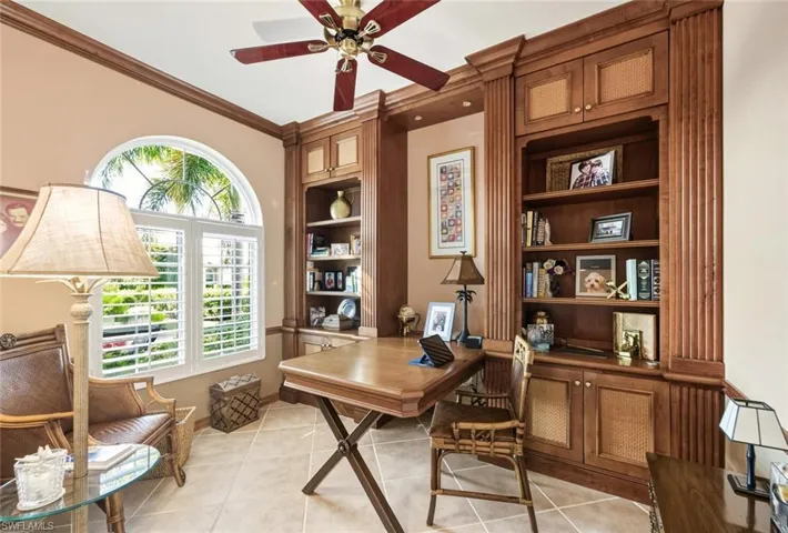 Home office featuring built in features, light tile patterned flooring, ceiling fan, and ornamental molding