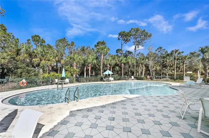Community pool with a patio and view of scattered trees