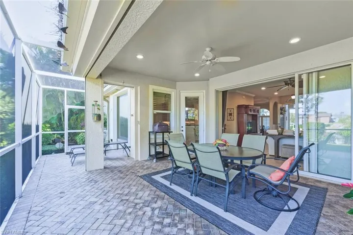 Sunroom / solarium featuring a ceiling fan, outdoor dining space, and a patio
