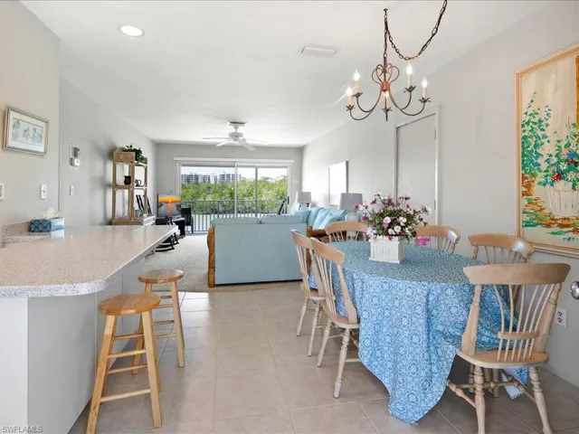 Dining space featuring light tile patterned floors, recessed lighting, and ceiling fan with notable chandelier