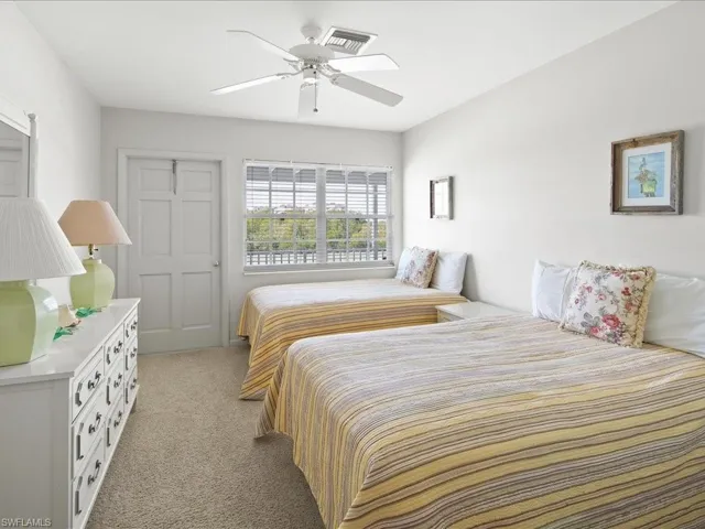 Bedroom featuring ceiling fan, visible vents, and light carpet
