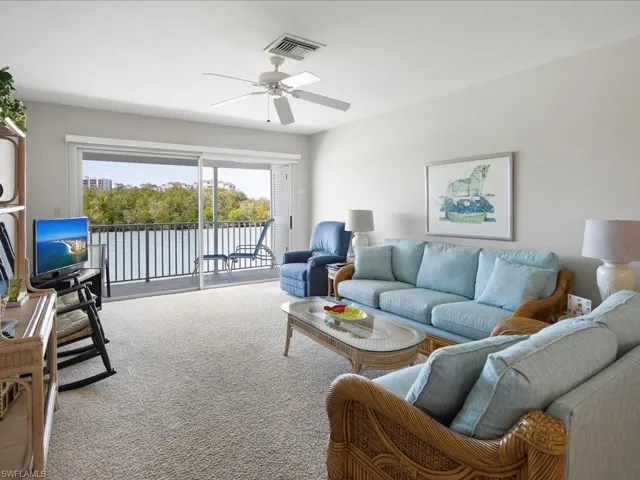 Carpeted living room with visible vents and a ceiling fan