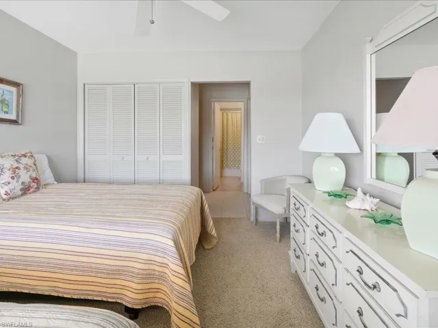 Bedroom with a closet, light carpet, and ceiling fan