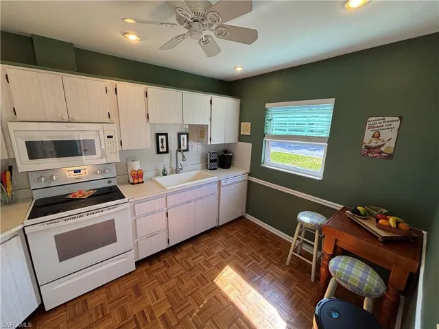 Kitchen featuring white appliances, light countertops, recessed lighting, a ceiling fan, and tasteful backsplash