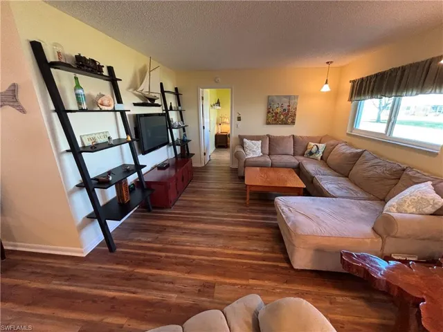 Living area featuring a textured ceiling and dark wood finished floors