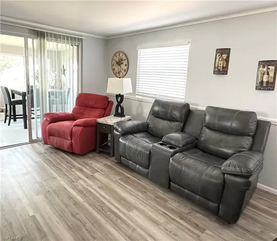 Living room with ornamental molding and wood-type flooring