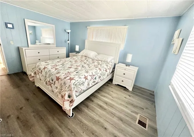Bedroom featuring hardwood / wood-style flooring and multiple windows