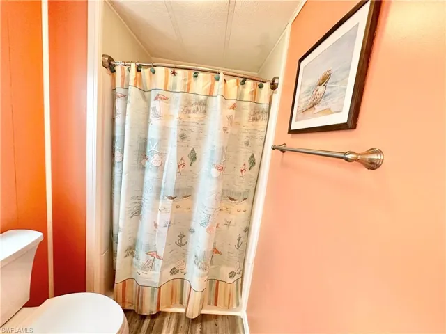 Bathroom featuring hardwood / wood-style floors, a textured ceiling, and toilet