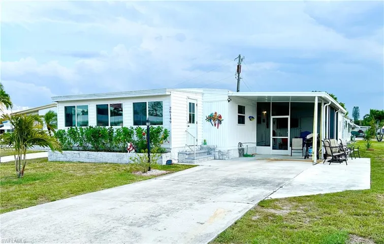 Manufactured / mobile home with a carport and a front lawn