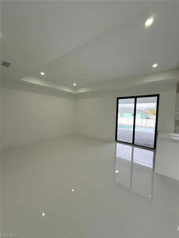 Empty room featuring tile patterned flooring and a raised ceiling