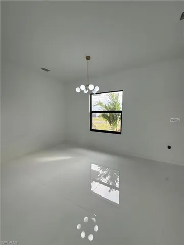 Unfurnished room featuring a notable chandelier