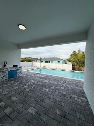 View of swimming pool with exterior kitchen and a patio area