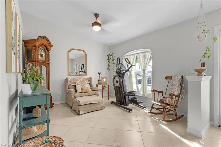 Sitting room featuring light tile patterned floors, ceiling fan, and baseboards