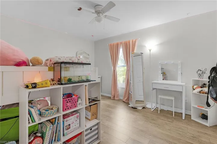 Playroom with wood finished floors, a ceiling fan, and baseboards