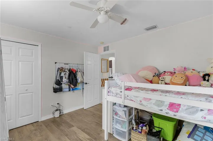Bedroom featuring a closet, visible vents, ceiling fan, wood finished floors, and baseboards