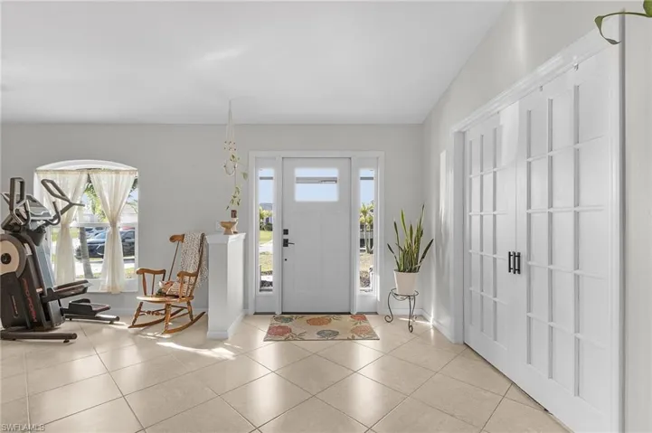 Entryway featuring light tile patterned floors and baseboards