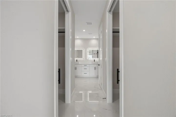 Corridor featuring recessed lighting and light marble finish floors