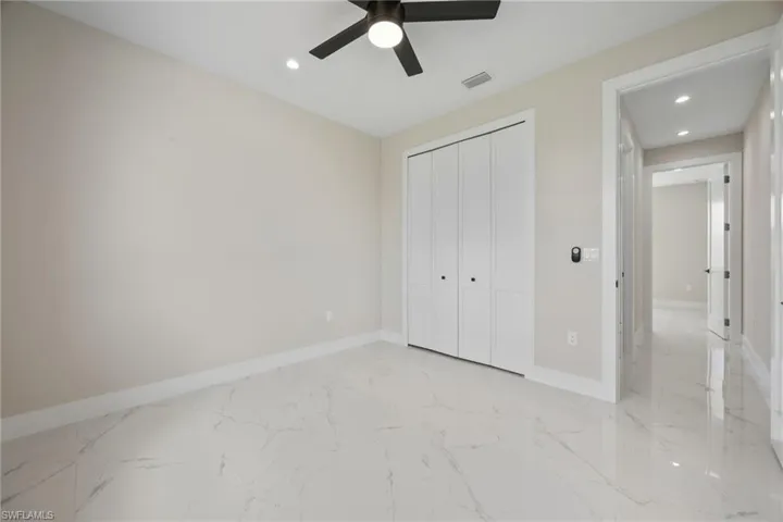 Unfurnished bedroom featuring light marble finish floors, recessed lighting, a ceiling fan, and a closet